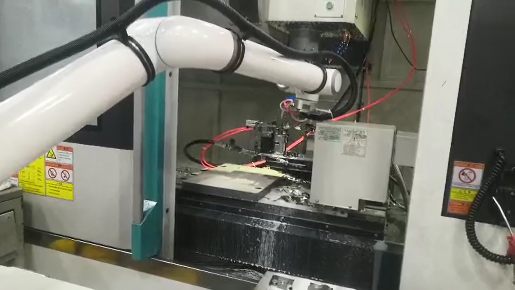 Elite Cobot from Robot Solutions QLD Robotic arm in a manufacturing setting with various components and wires.